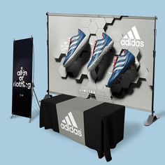 a display with three adidas shoes on it next to a black and white table cloth