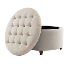 a white round ottoman sitting on top of a wooden table