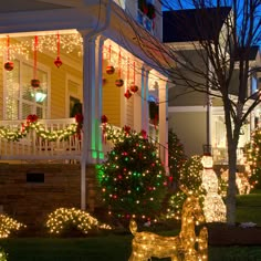 christmas lights decorate the front yard of a house in this suburban neighborhood, with lighted deer statues and trees