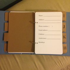 an open planner book sitting on top of a bed