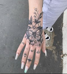 a woman's hand with tattoos and flowers on it