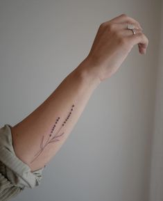 a woman's arm with a flower tattoo on the left side of her arm