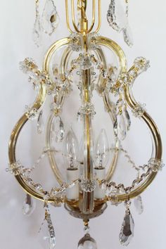 a gold chandelier with crystal drops hanging from it