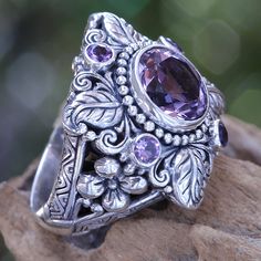 Faceted and polished amethyst crowns this elegant ring. Kadek Hendra works in sterling silver and amethysts totaling 3.4 carats. The handcrafted design reveals its Balinese origin with luscious flower and plant motifs. .925 Sterling silver Elegant Purple Amethyst Flower Ring, Stamped 925 Amethyst Ring Fine Jewelry, Amethyst Flower, Bohemian Rings, Purple Crystals, Crystal Flower, Amethyst Stone, Flower Ring, Crystal Rings