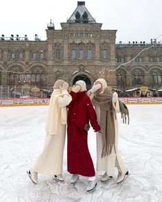 three women standing in front of an ice rink