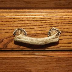 a close up of a drawer handle on a wooden surface