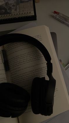 an open book with headphones on top of it