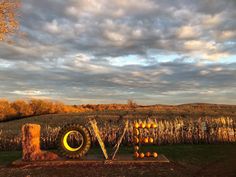 the word love is made out of pumpkins and hay in front of a corn field