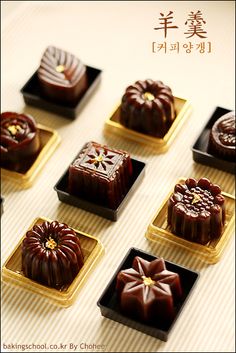 there are many different types of chocolates on the table together with chinese characters in the background