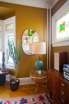 a living room filled with furniture and a mirror on the wall next to a window