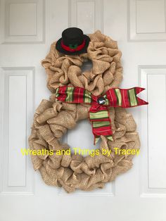 a burlock wreath with a top hat and scarf hanging on the front door