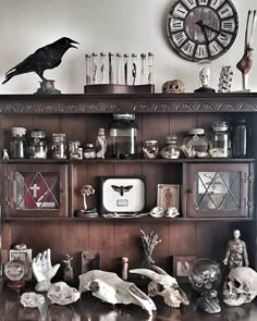 there is a shelf with skulls and other items on it in front of a clock