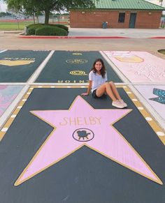 a woman sitting on the ground in front of a star