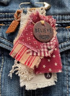 a badge on the back of a jean jacket that says believe and has been pinned to it