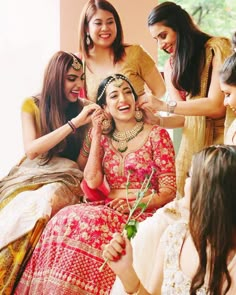 a group of women standing next to each other in front of a woman holding a flower