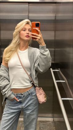 a woman taking a selfie with her phone in front of an escalator