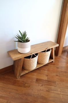 a wooden shelf with two baskets and a potted plant