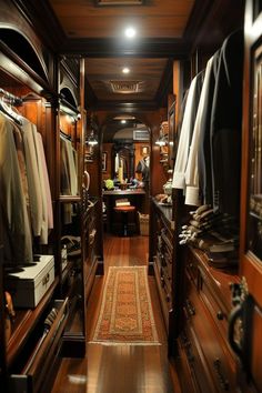 a large walk in closet with lots of clothes hanging on the walls and wooden flooring