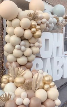 balloons are stacked on top of each other in front of a sign that says oh baby