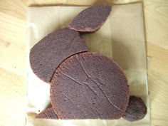 two chocolate cookies sitting on top of a piece of wax paper next to each other