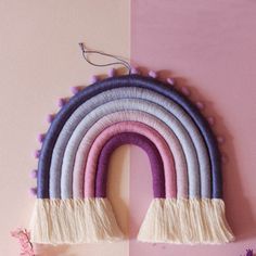 a wall hanging made out of yarn and tassels with a rainbow on it