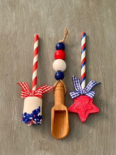 three wooden spoons with patriotic decorations on them, one is holding a toothbrush