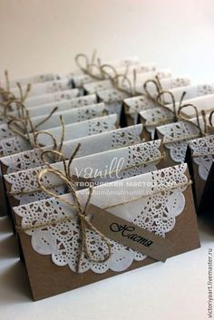 small gift bags with lace and twine on them are tied up in brown paper