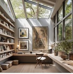 a home office with lots of bookshelves and pictures on the wall above it