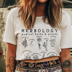 H e r b o l o g y :  the study or collecting of herbs. *W A S H   D A Y* Please follow these instructions carefully to avoid fading and cracking of the print, and shrinking the garment that can occur if you wash or dry it on a high setting. *Machine-wash cold, inside-out on a gentle cycle with a mild detergent and like colors. *Use non-chlorine bleach only when necessary. You shouldn't use any fabric softeners or dry-clean the items. *Tumble-dry on a low cycle, but hang-dry works best. *Don't iron the print. * 100% combed and ring-spun cotton (Heather colors contain polyester) * Ash color is 99% combed and ring-spun cotton, 1% polyester * Heather colors are 52% combed and ring-spun cotton, 48% polyester * Athletic and Black Heather are 90% combed and ring-spun cotton, 10% polyester * Heath Magical Plants, Jean Jacket Outfits, Nashville Outfits, Boho Fashion Summer, Black Jeans Outfit, College Shirts, Branding Photoshoot, The Study, Comfort Colors Tee