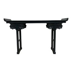 an ornate black console table against a white background