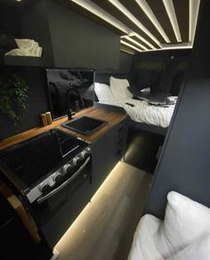 the interior of an rv with two beds and a stove top oven in front of it