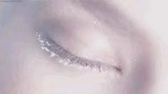 a woman's eye with long lashes and glitter on the bottom part of her eyelashes