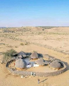 an aerial view of some huts in the desert