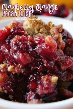 cranberry orange pecan crisp is in a white bowl on a wooden table