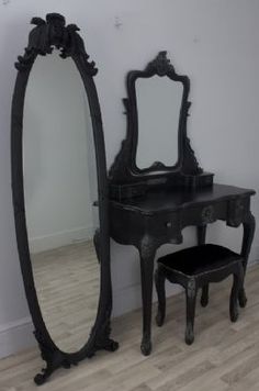 an antique vanity with mirror and stool in a room