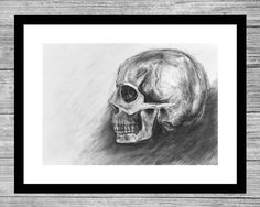 a black and white drawing of a skull on a wood background with a wooden frame