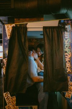 two people hugging each other while sitting in a booth