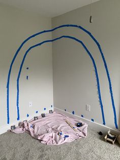 a room that has been painted with blue tape and some paintbrushes on the wall