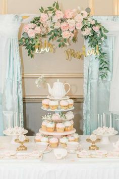 a table topped with cupcakes and cakes covered in frosting