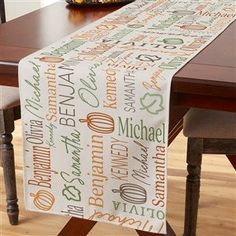 a dining room table with a personalized name on it and a bowl of fruit