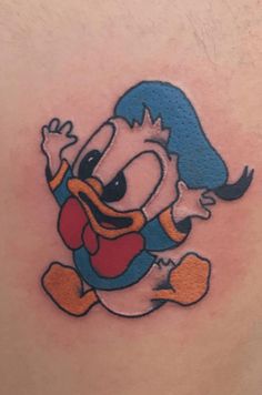 a cartoon character tattoo on the back of a man's stomach, with an image of donald duck