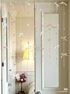 some pink and white streamers hanging from the ceiling above a bed in a room