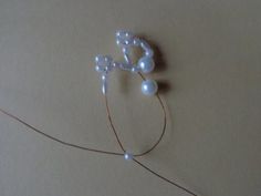 a string with pearls attached to it sitting on a table next to a piece of paper