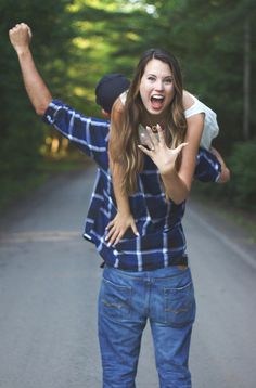 a woman is riding on the back of a man's shoulders while he holds her up