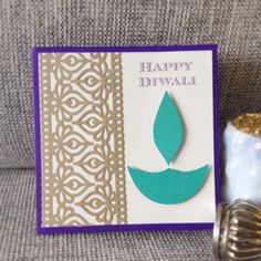 there is a card with a blue flower on it and a candle next to it