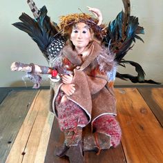 a figurine sitting on top of a wooden floor next to a bird statue