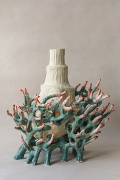 a ceramic vase sitting on top of a table next to corals and other items