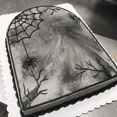 a cake decorated with spider webs on top of a white paper towel and napkin