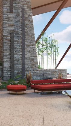 a red couch sitting on top of a patio next to a fire place