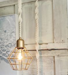 a light that is hanging from the ceiling in front of a wall with wood paneling